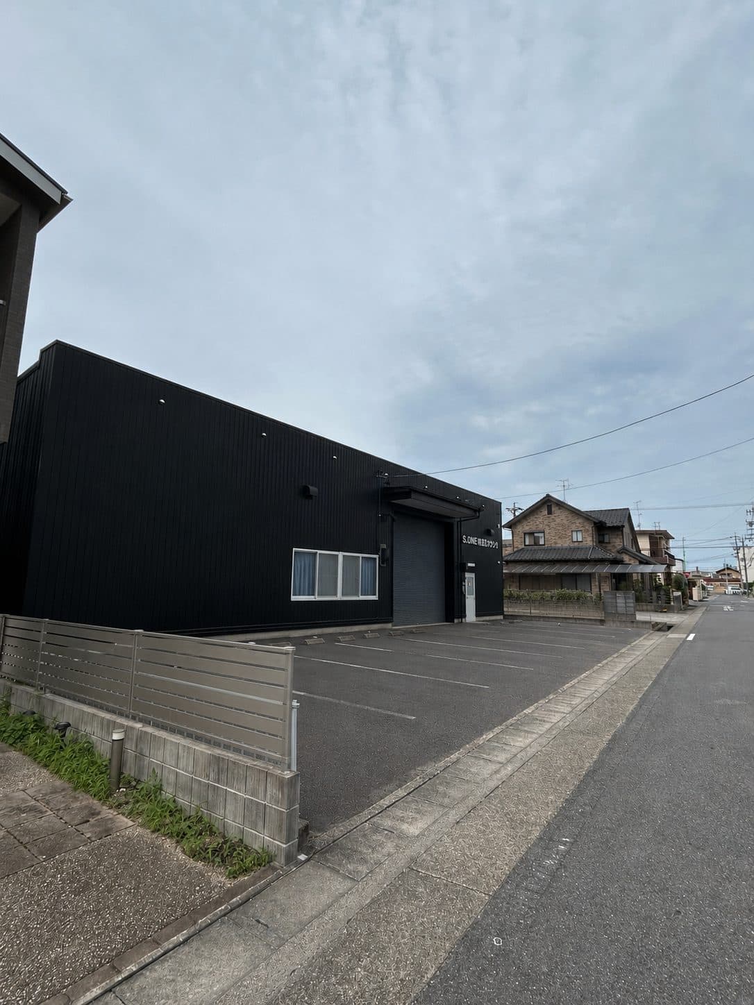 昼のS_ONE卓球スタジオの外観と、建物前の無料駐車場7台